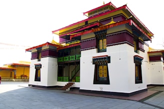 A white and red building with a red car parked in front of it