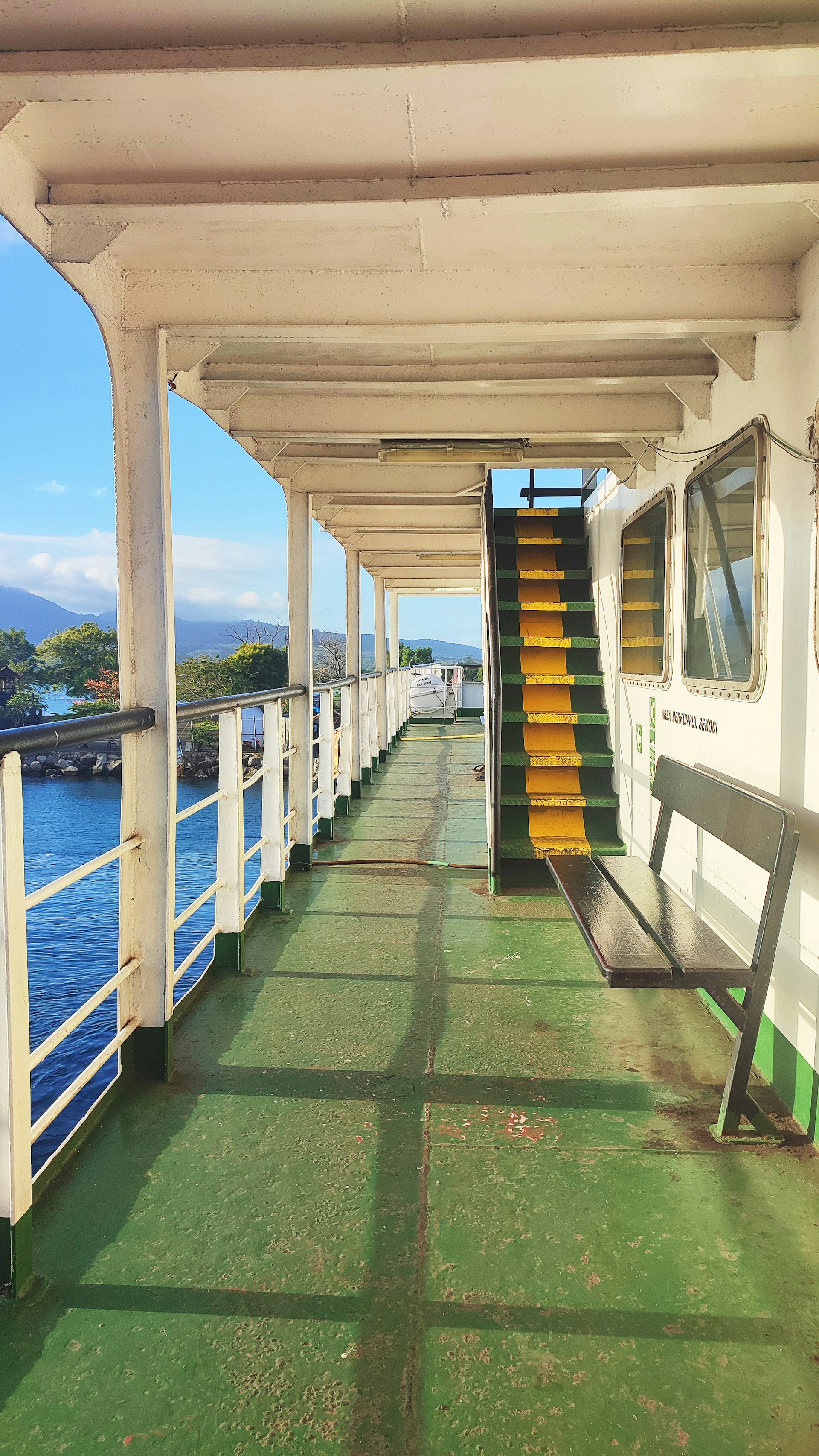 A long covered walkway with a bench on the side of it