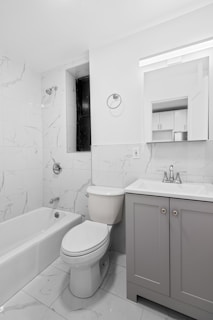 A bathroom with a toilet, sink, and bathtub