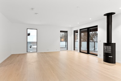 An empty room with a wood floor and a fire place