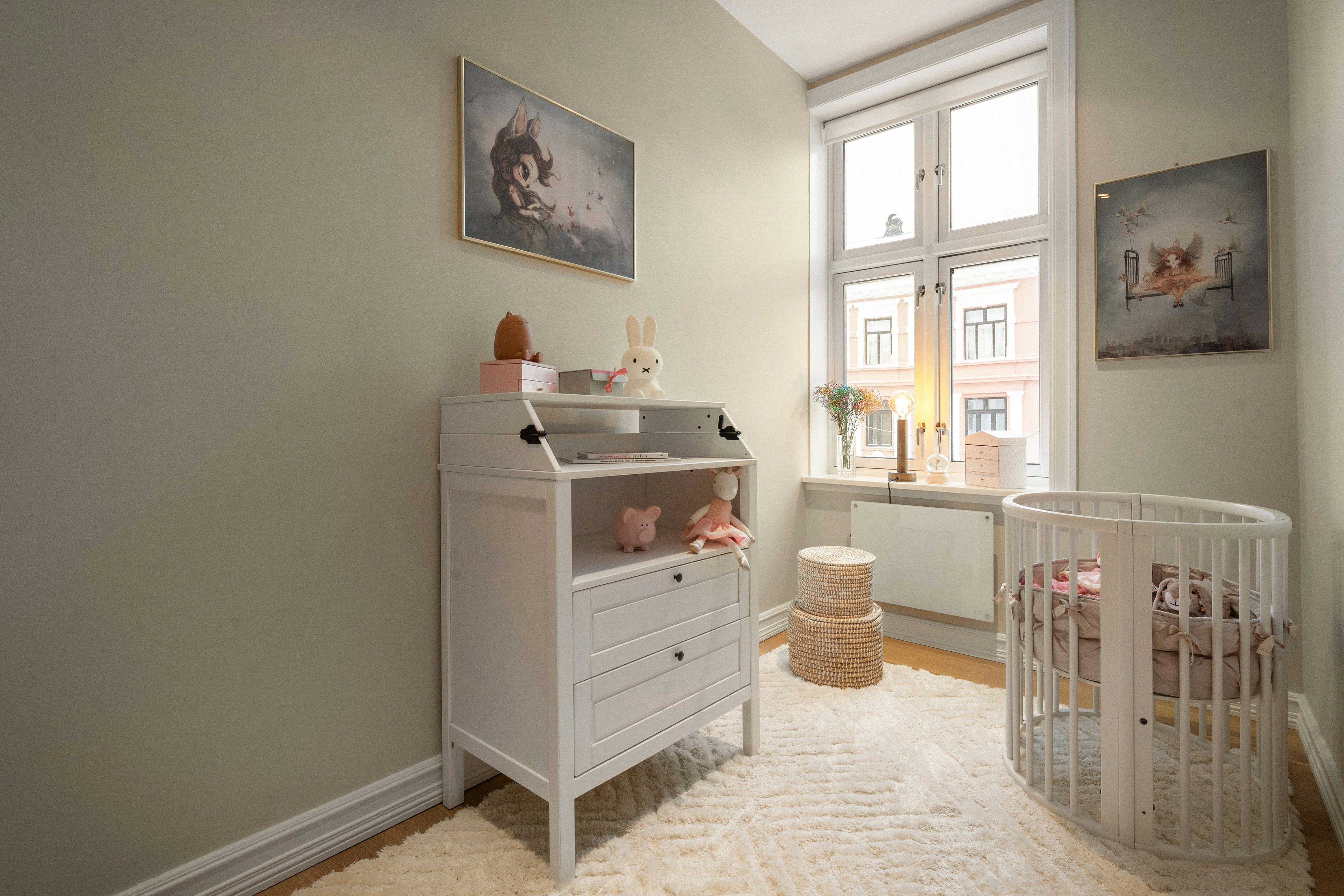 safe and serene nursery setup with a bassinet and changing station - new mom necessities