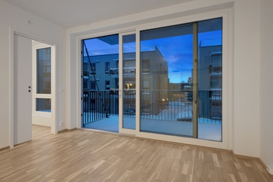 An empty room with a large sliding glass door
