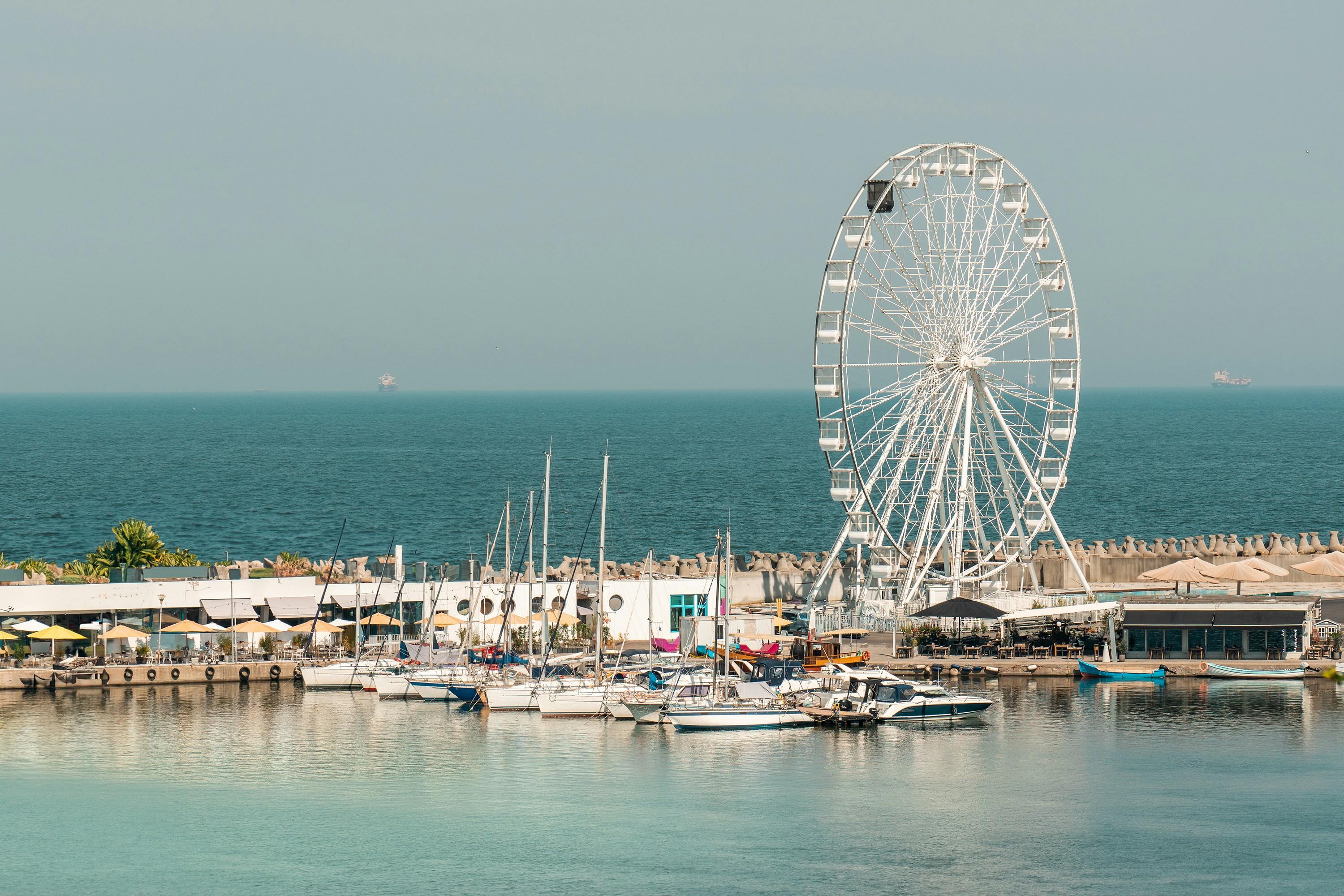 A ferris wheel sitting on top of a pier next to the ocean