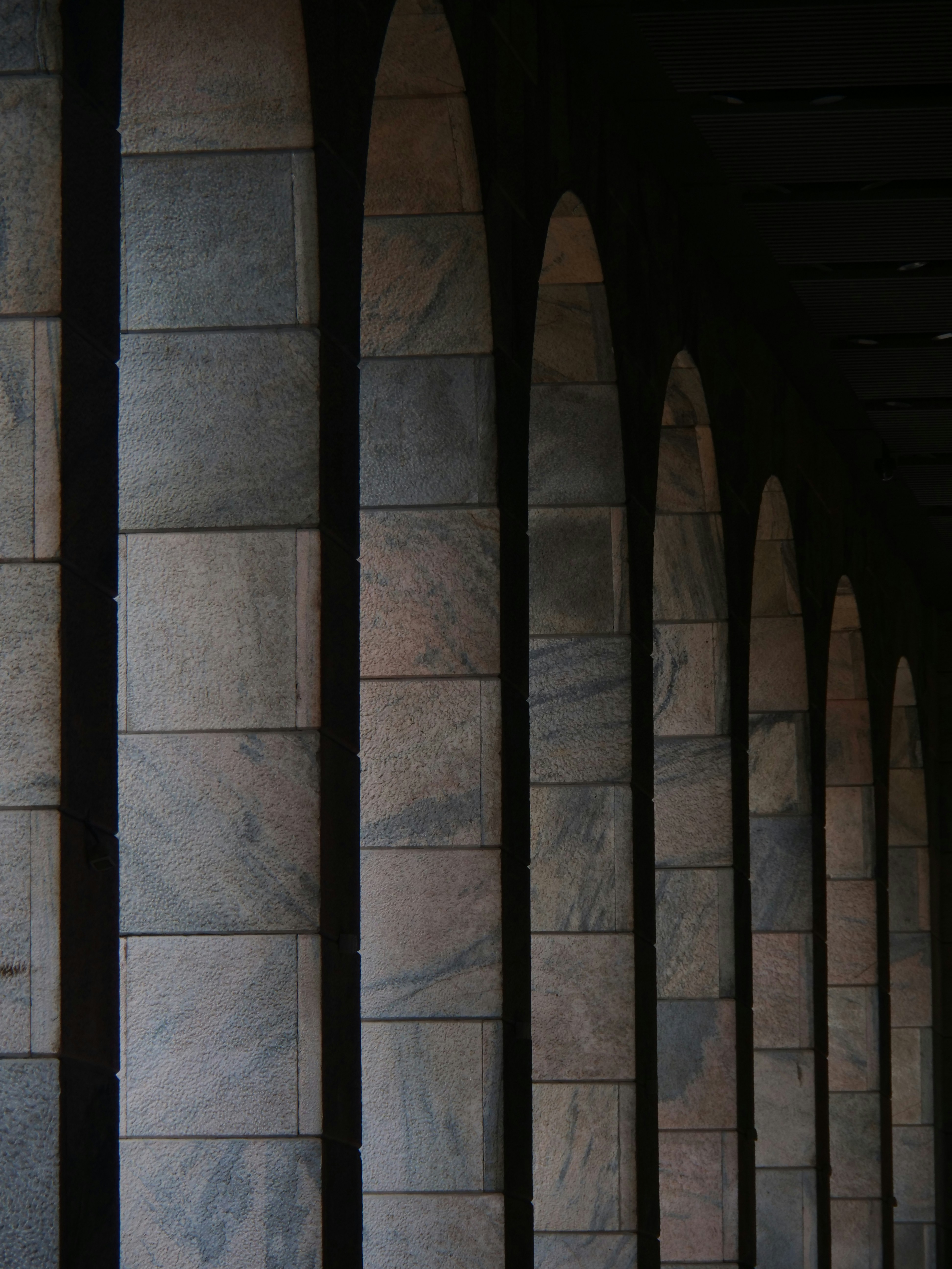A man in a suit and tie standing in front of a wall