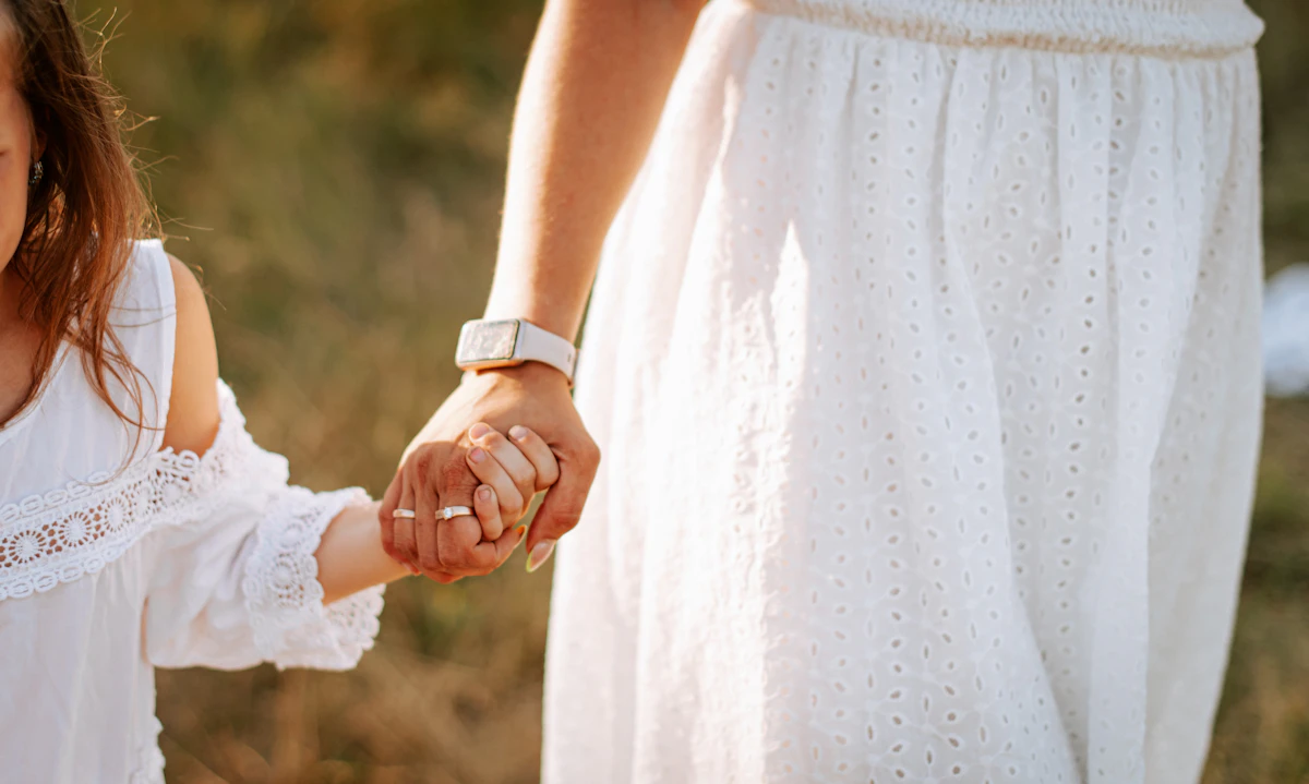 Anak perempuan kecil menggandeng tangan ibunya