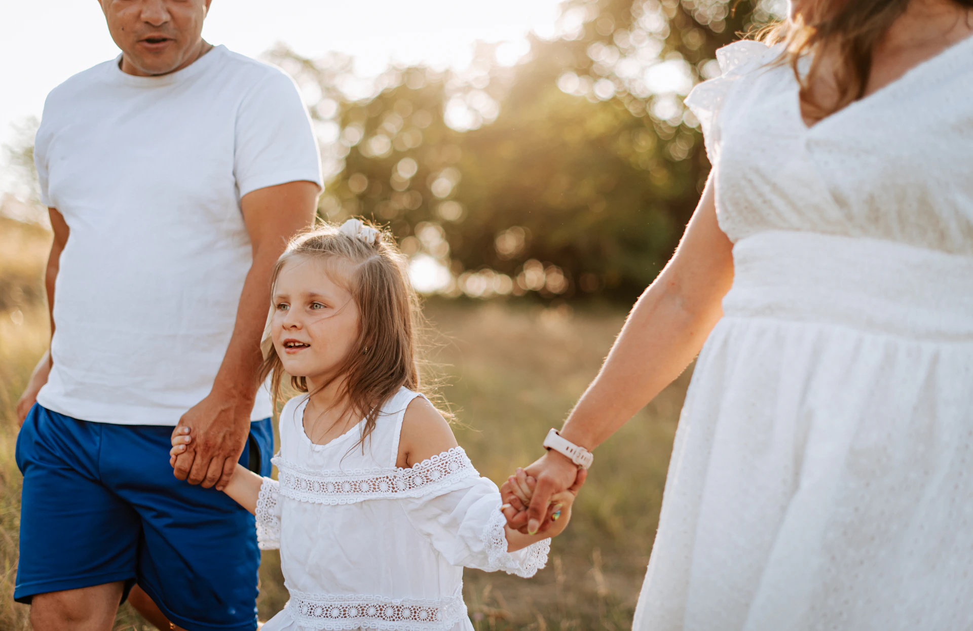 A man and a woman holding hands with a little girl