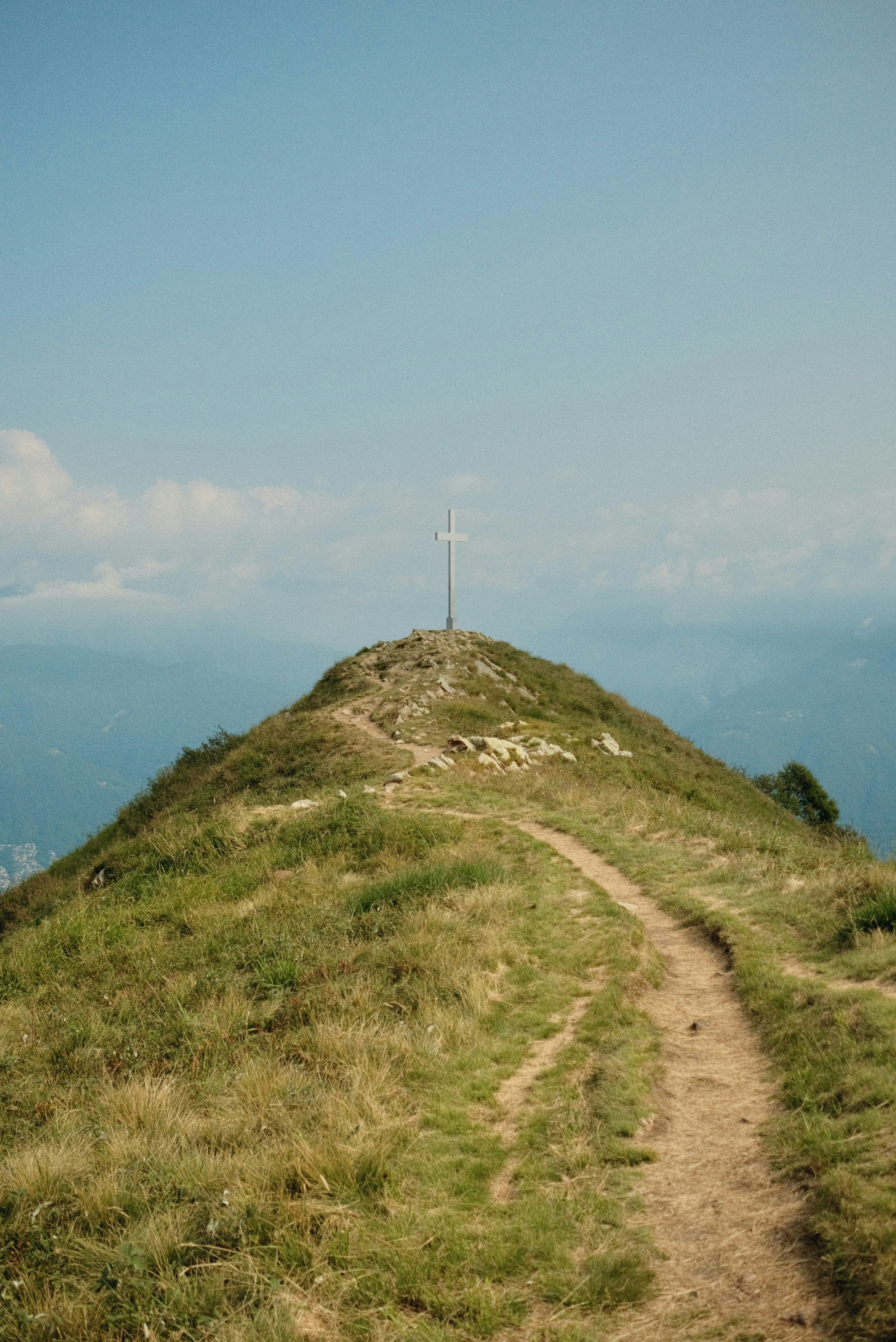 A cross on top of a grassy hill