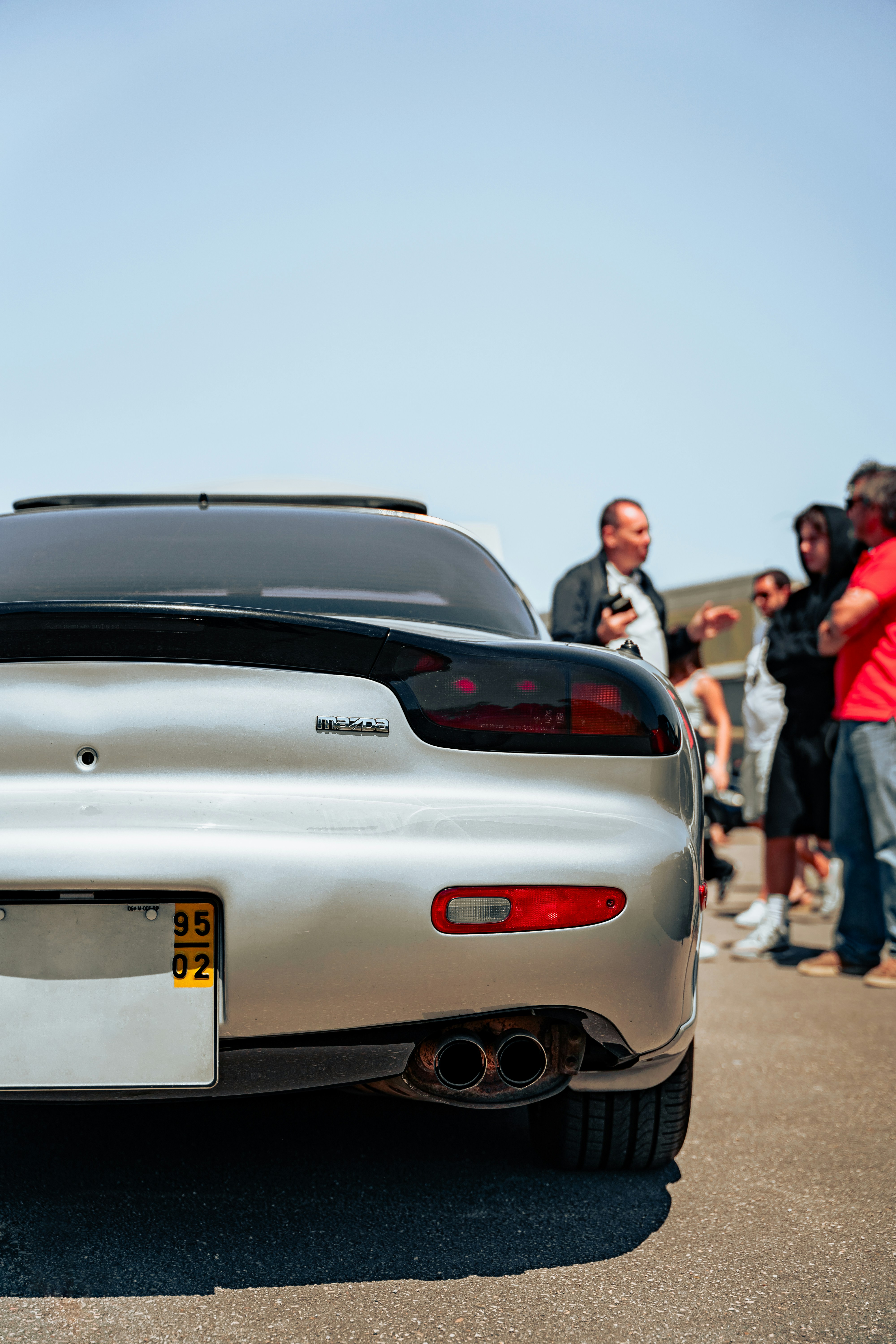 Um carro esportivo prateado estacionado em um estacionamento
