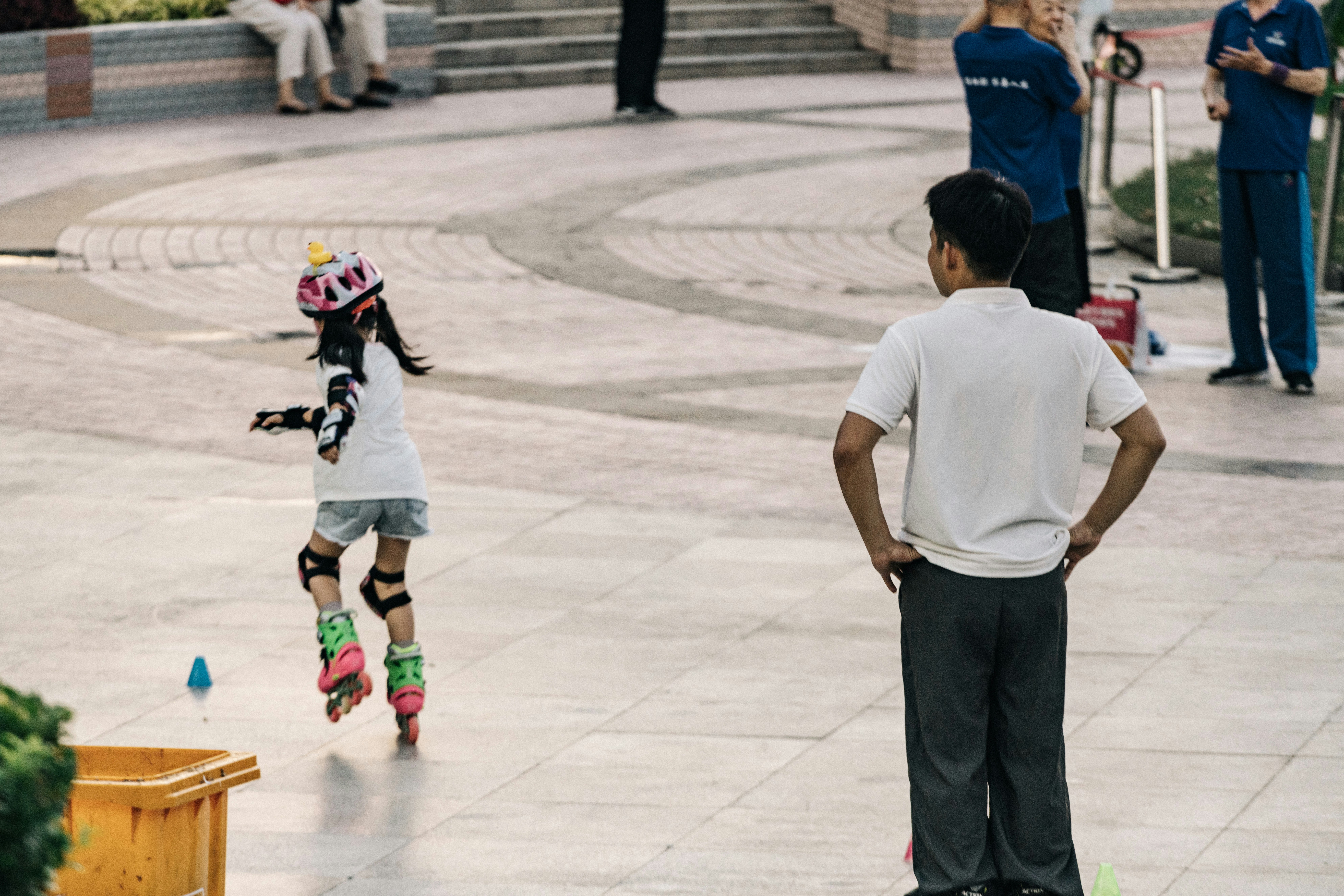 A young boy riding a skateboard down a sidewalk
