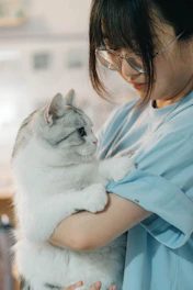 A woman holding a cat in her arms
