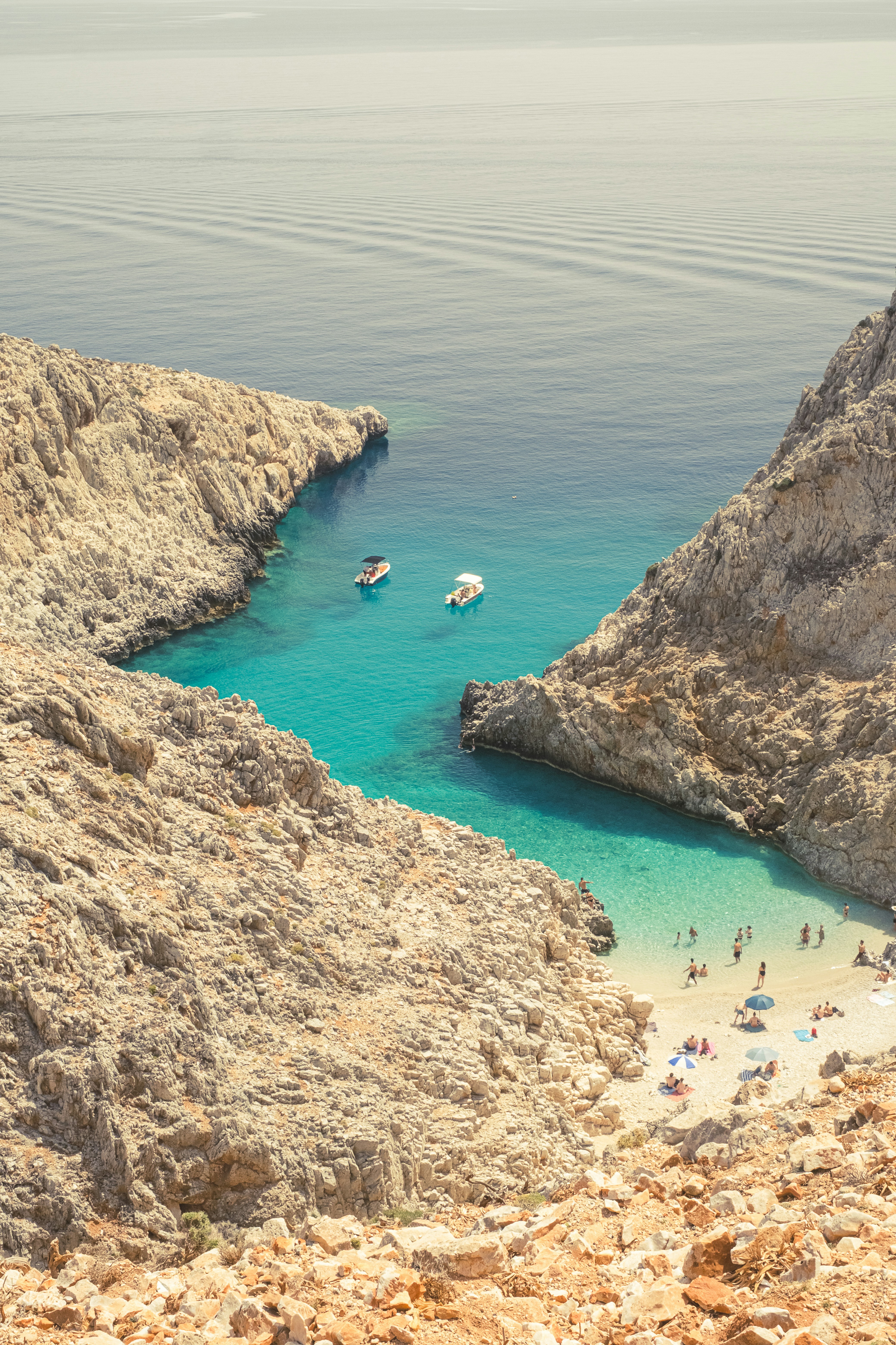 A group of people on a beach next to a cliff