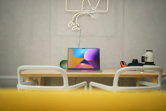A laptop computer sitting on top of a wooden table