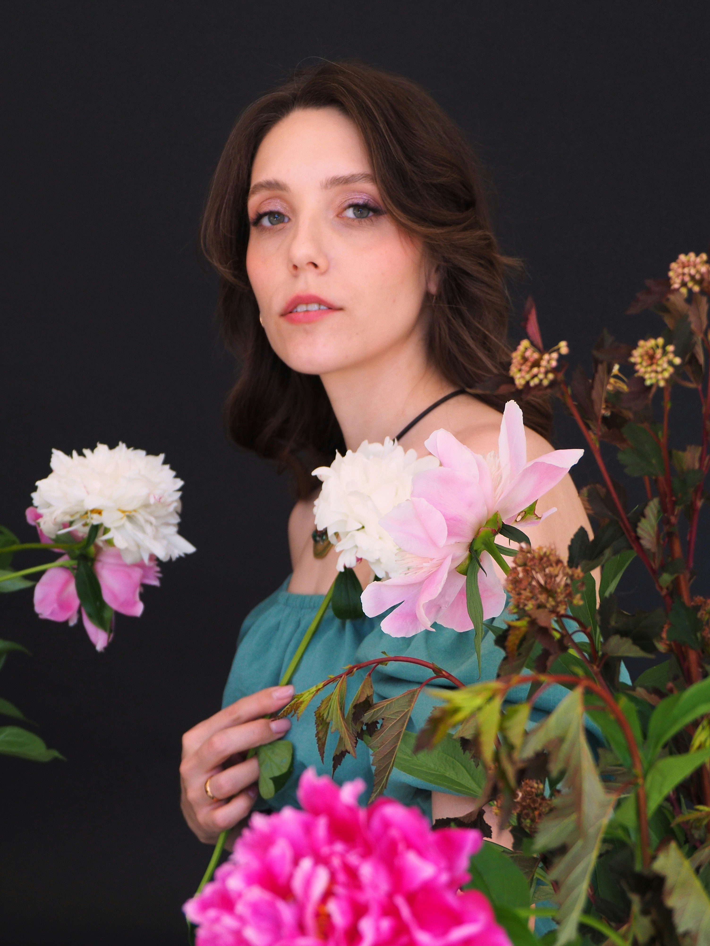 A woman in a blue dress holding a bouquet of flowers