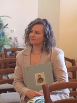 A woman sitting on a chair holding a book