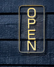 A sign that reads open on a wooden wall