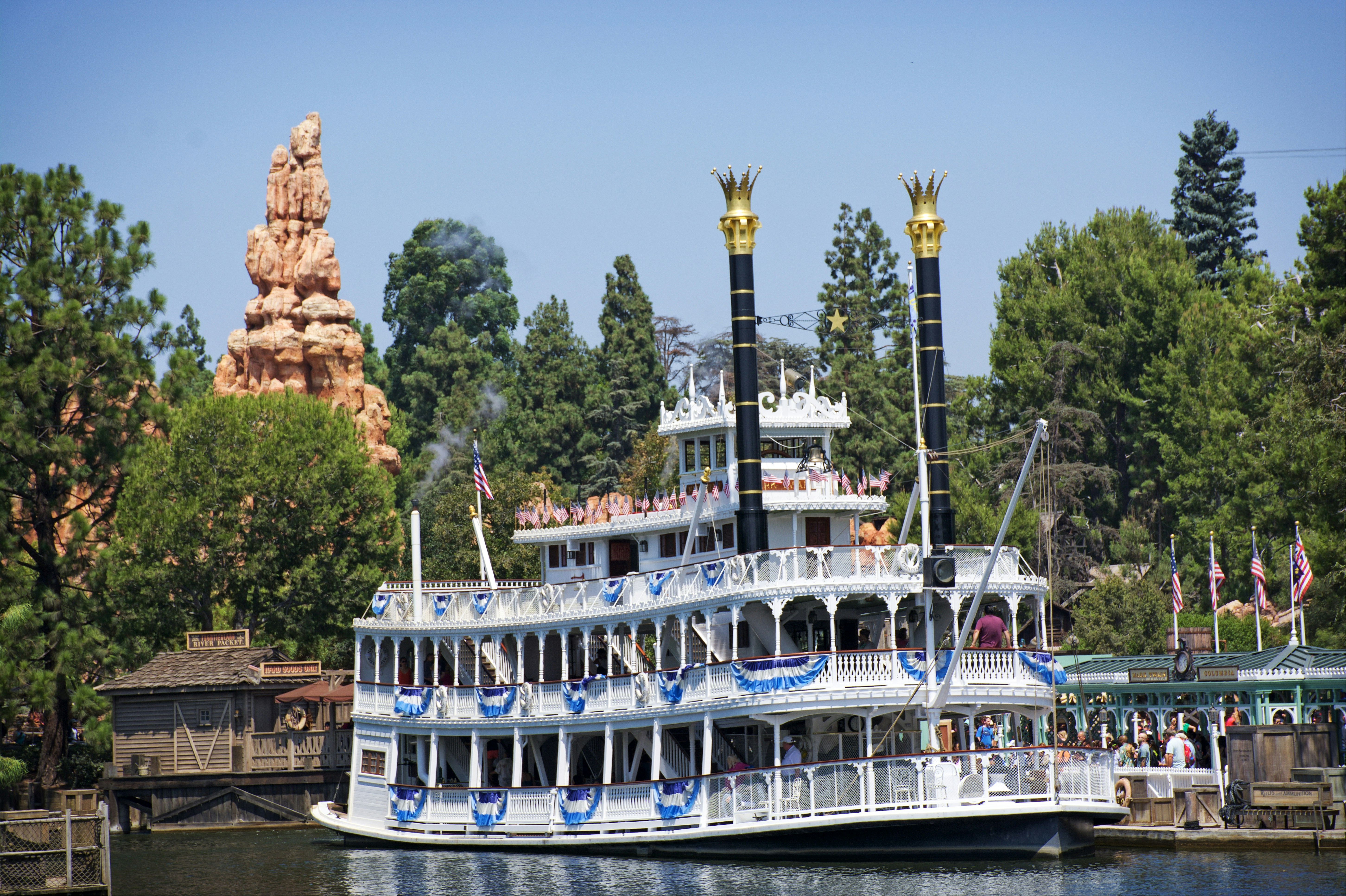A large white boat floating on top of a river