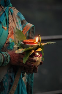 A woman holding a lit candle in her hands