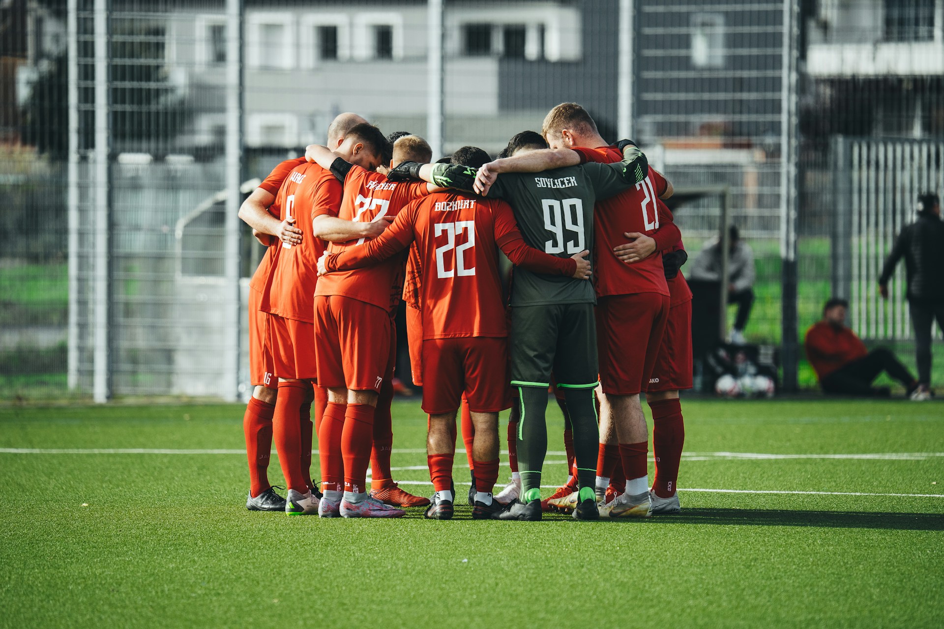 A group of soccer players huddle together on the field