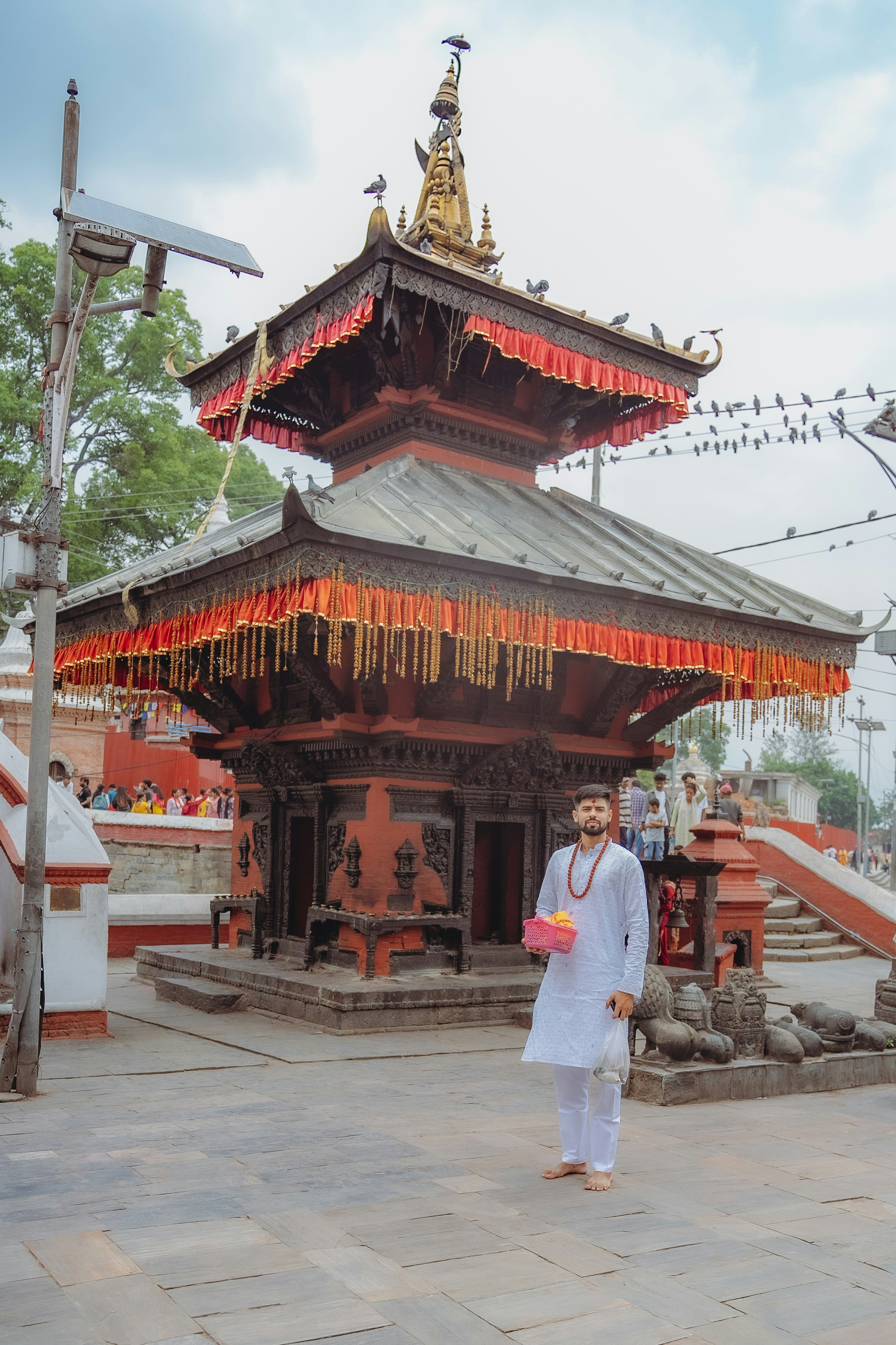 Seorang pria berdiri di depan pagoda