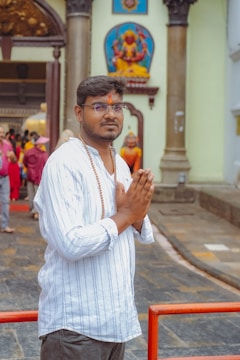 A man standing in front of a building with his hands folded