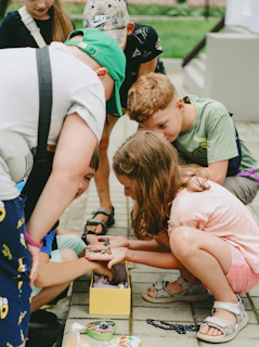 A group of children sitting on the ground playing a game
