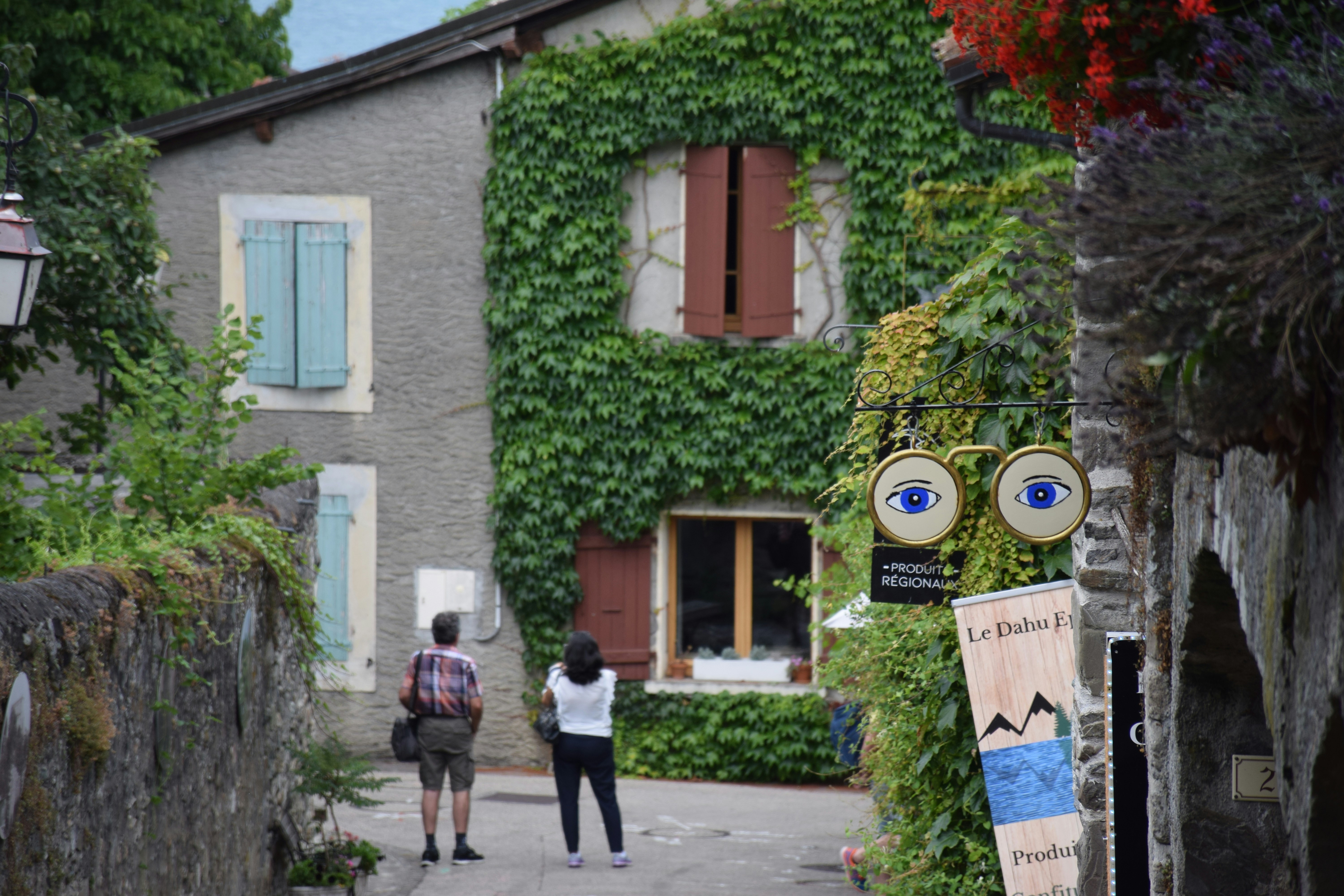 A couple of people walking down a street next to a building