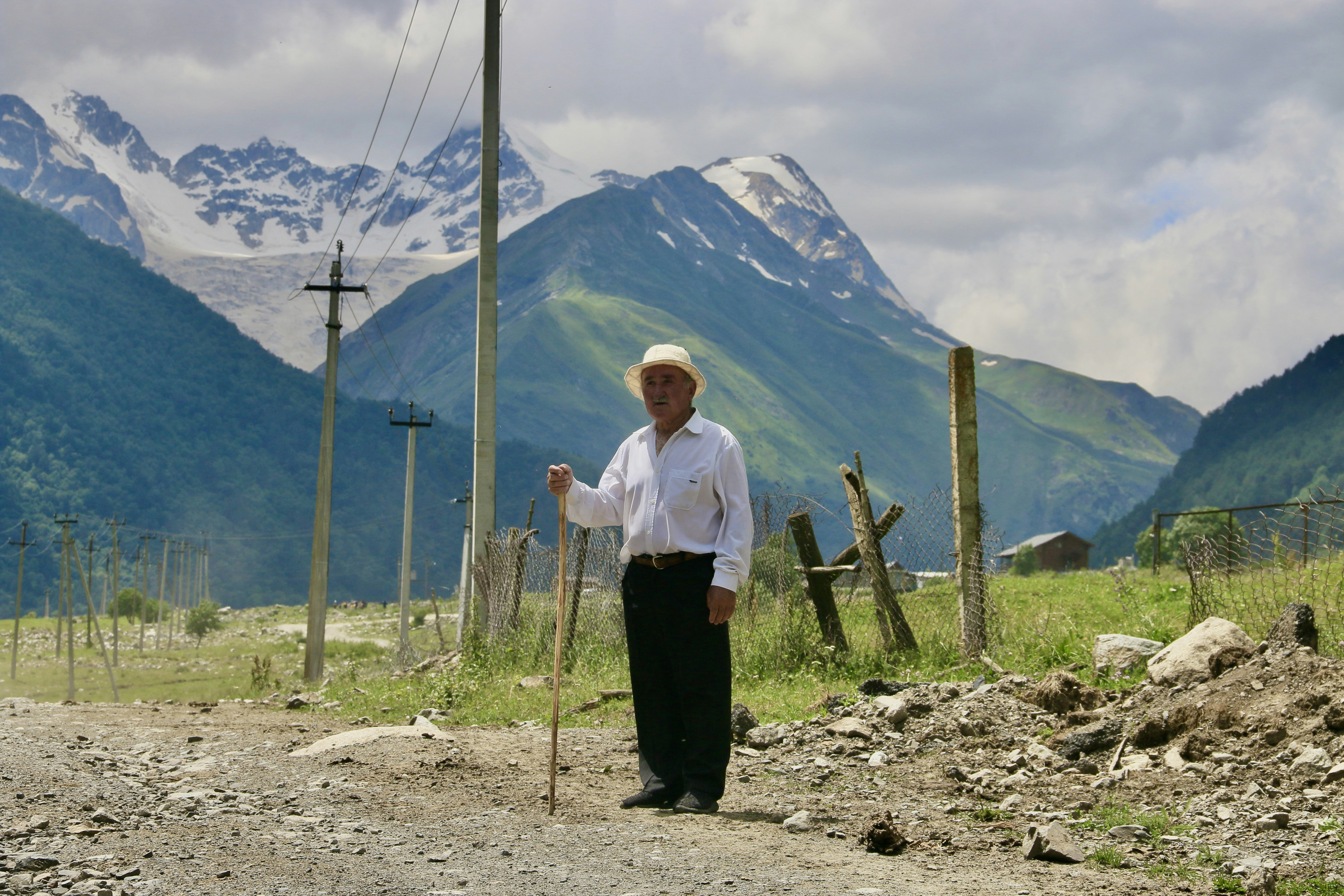 A man standing on a dirt road with mountains in the background (Photo by Polina Koroleva on Unsplash)