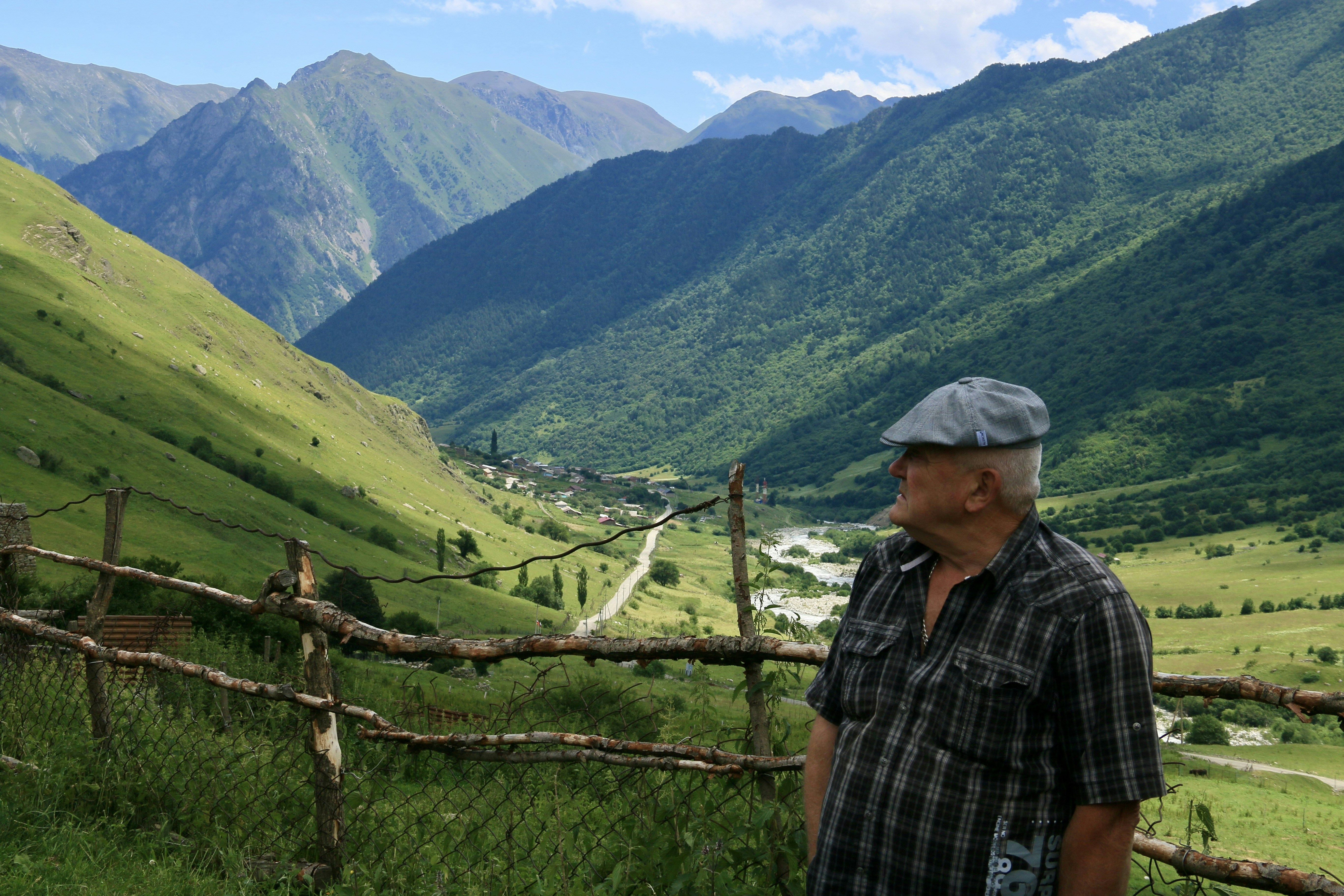 A man standing in front of a wooden fence