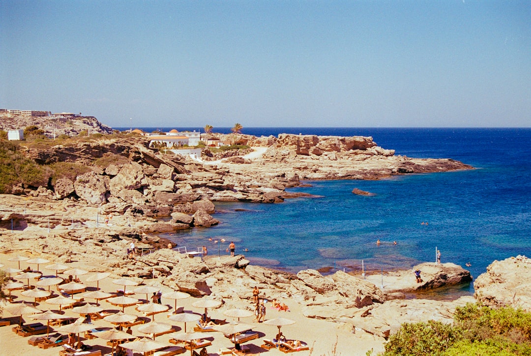 A group of people laying on top of a sandy beach,