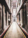 A train track in a large building with statues on it