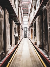 A train track in a large building with statues on it