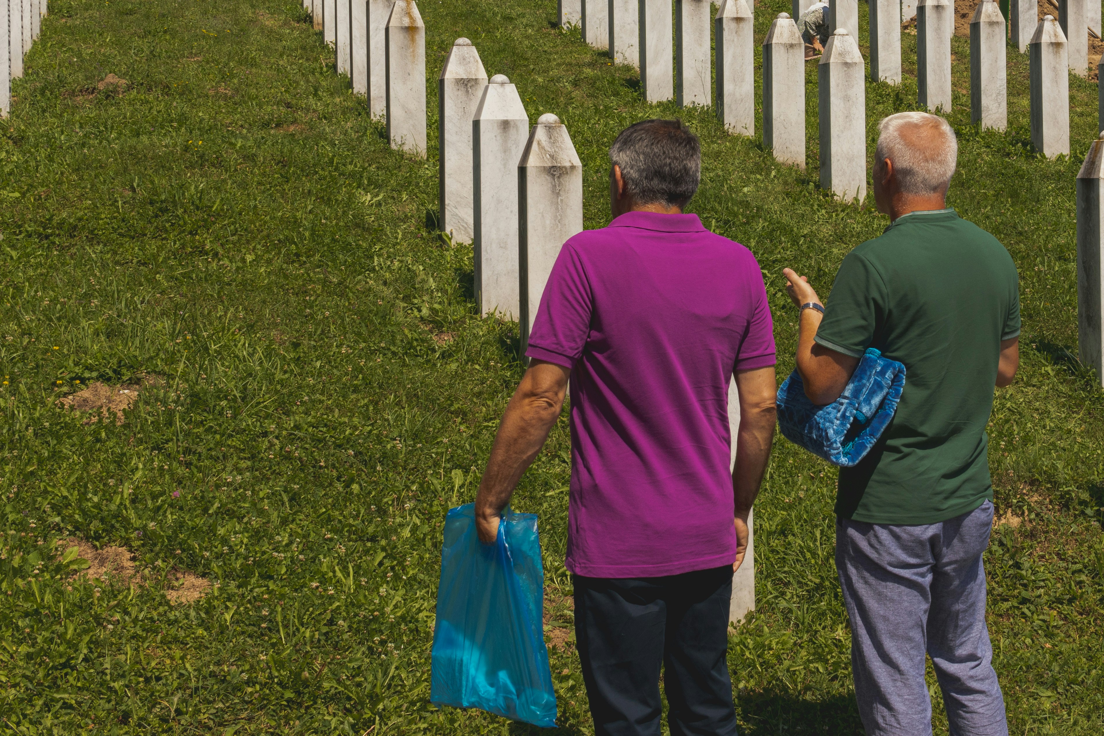 Un par de personas que están de pie en la hierba