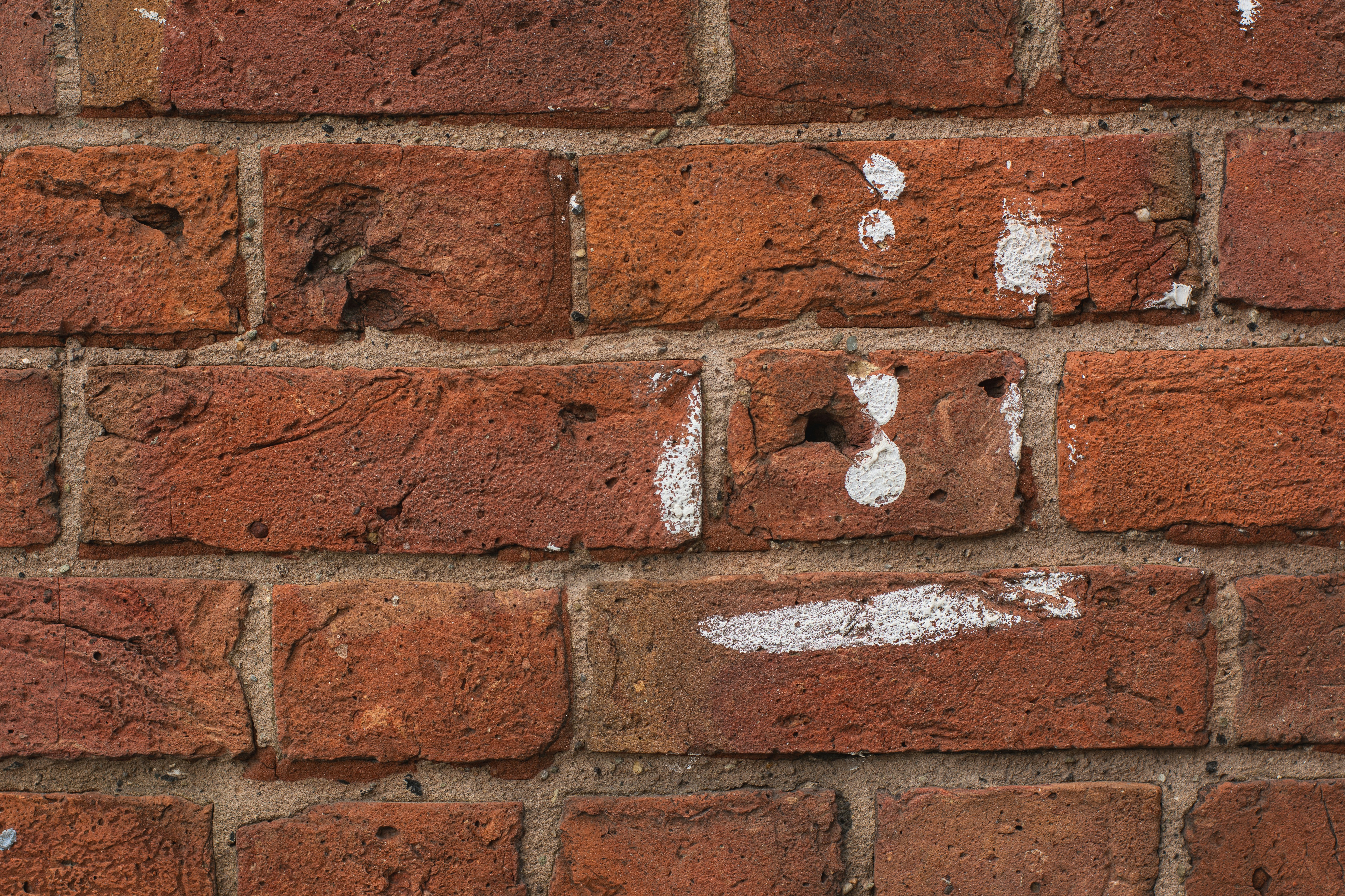 A close up of a brick wall with white paint