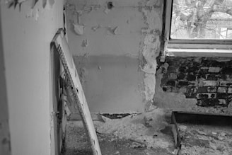 A room with a broken wall and a broken window