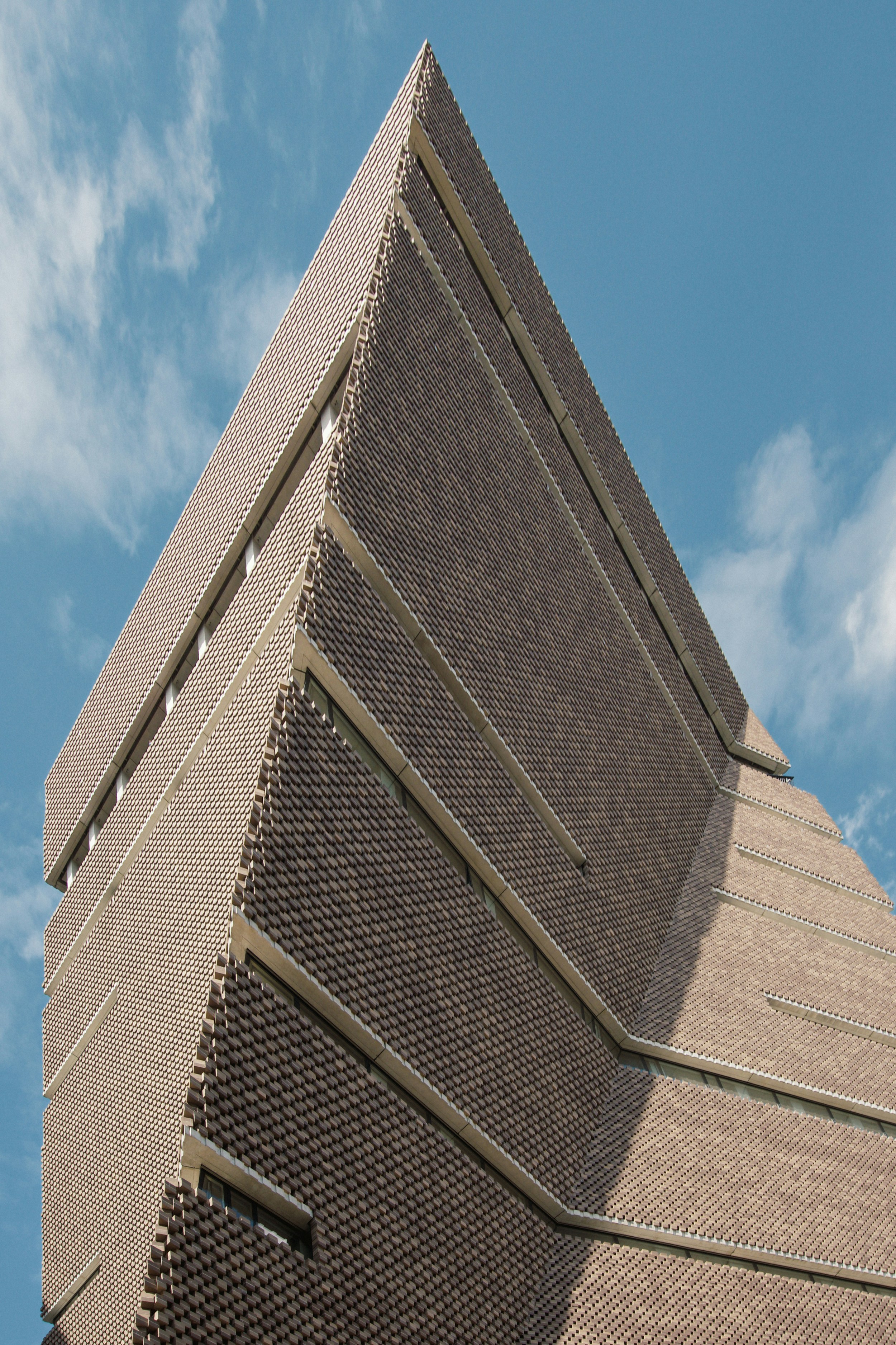 A tall brick building with a sky background