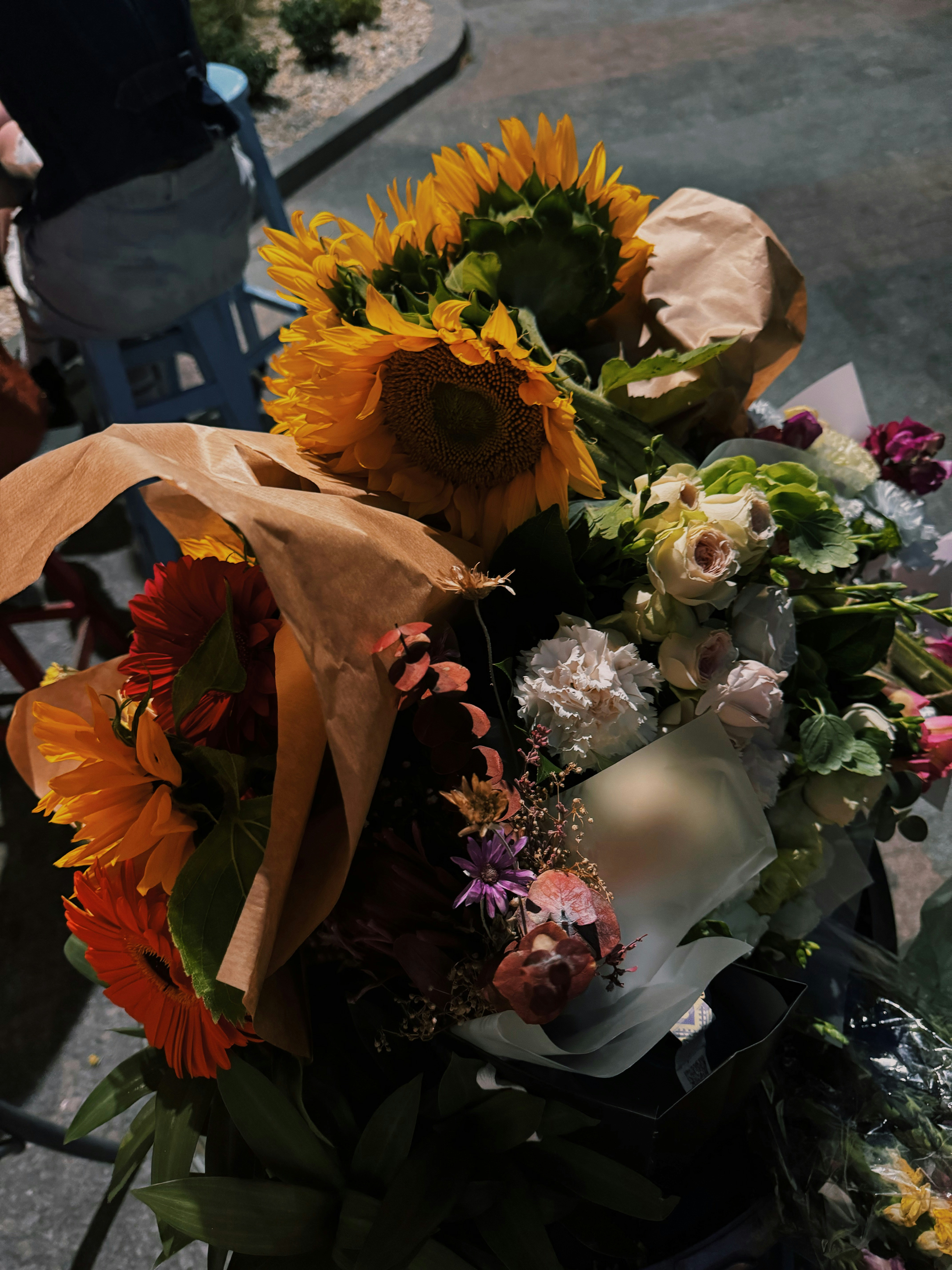 Vibrant wildflower bouquet with mixed colors wrapped in brown kraft paper, bright natural light