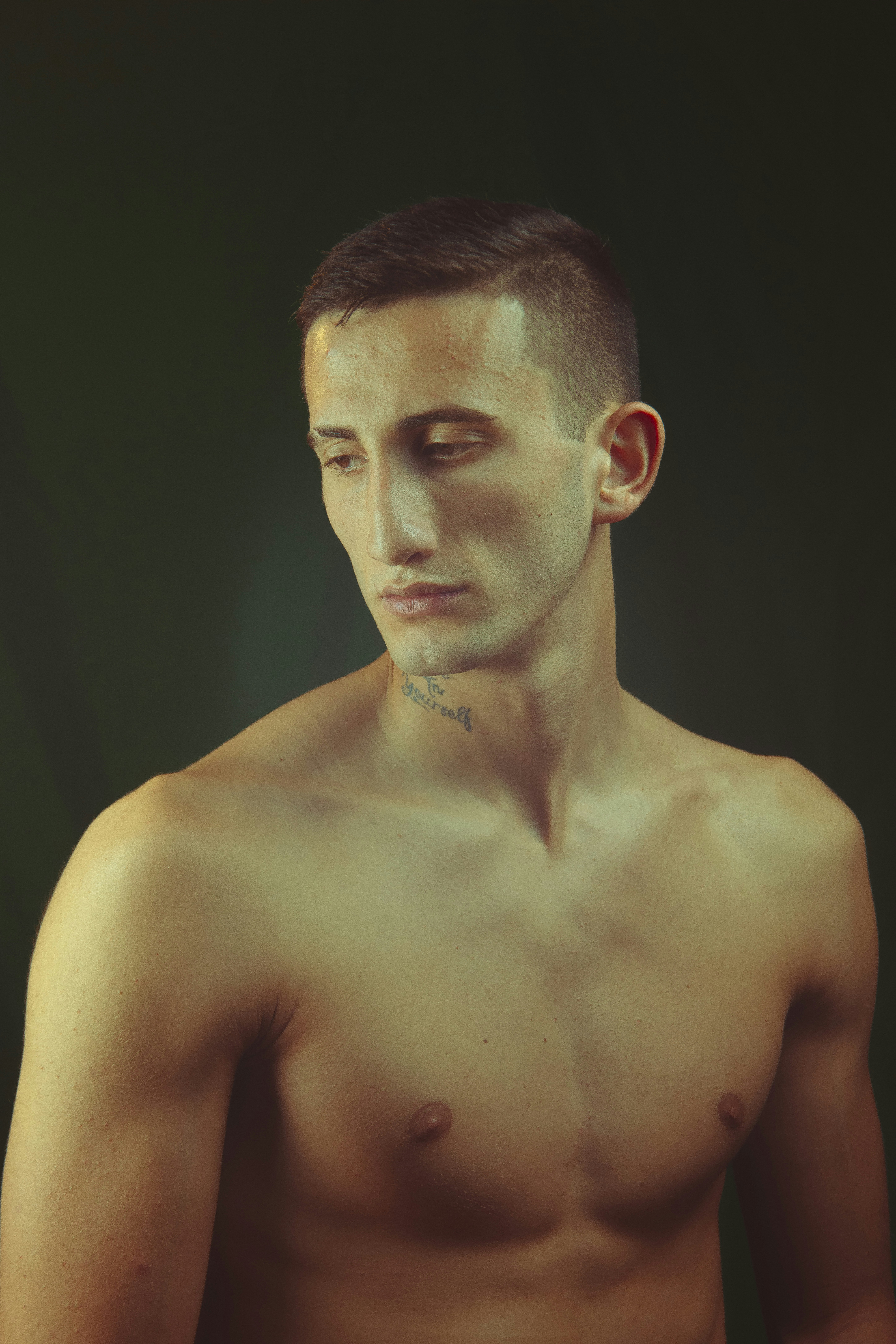 A shirtless man holding a cell phone in his hand