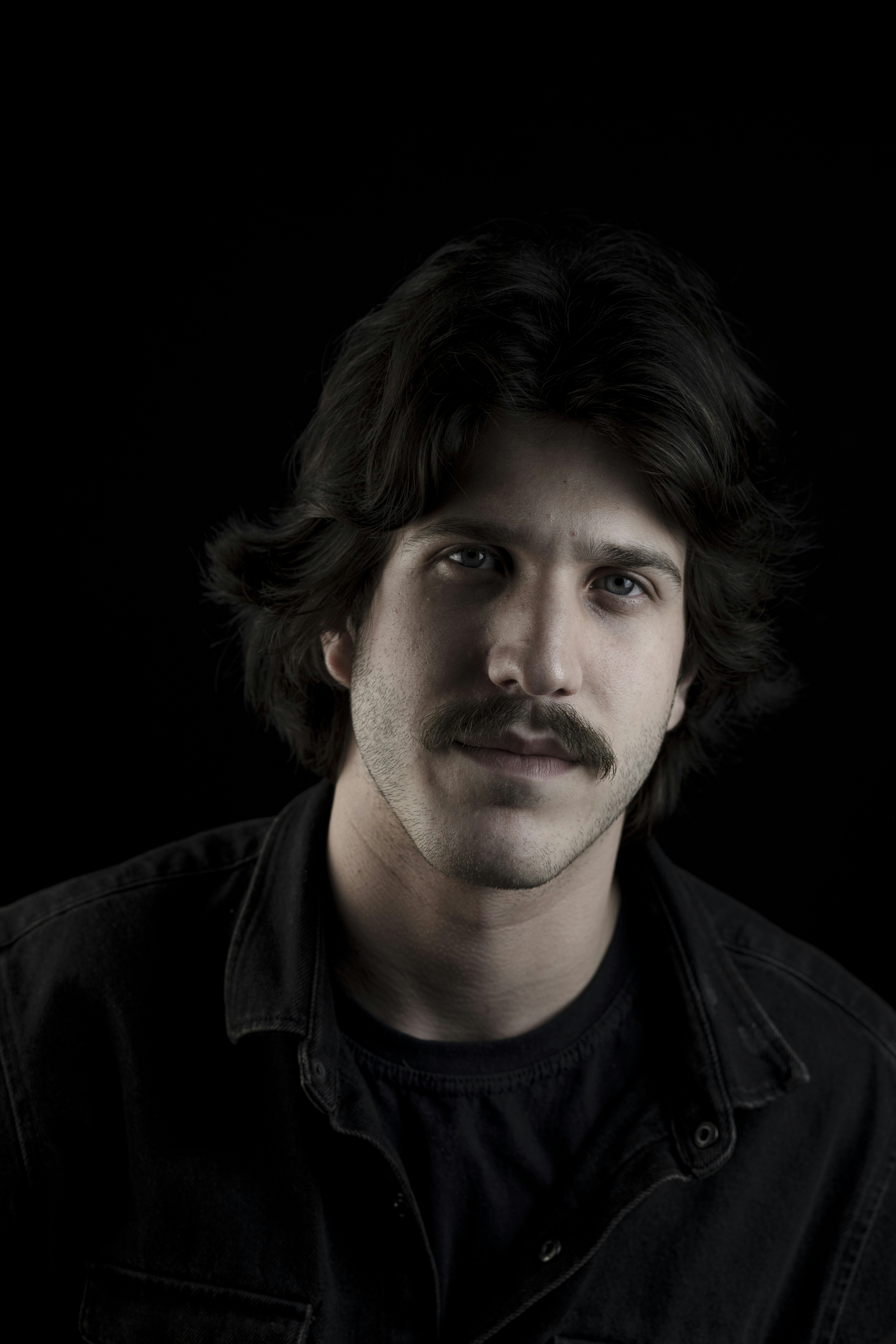 A man with a mustache and a black shirt