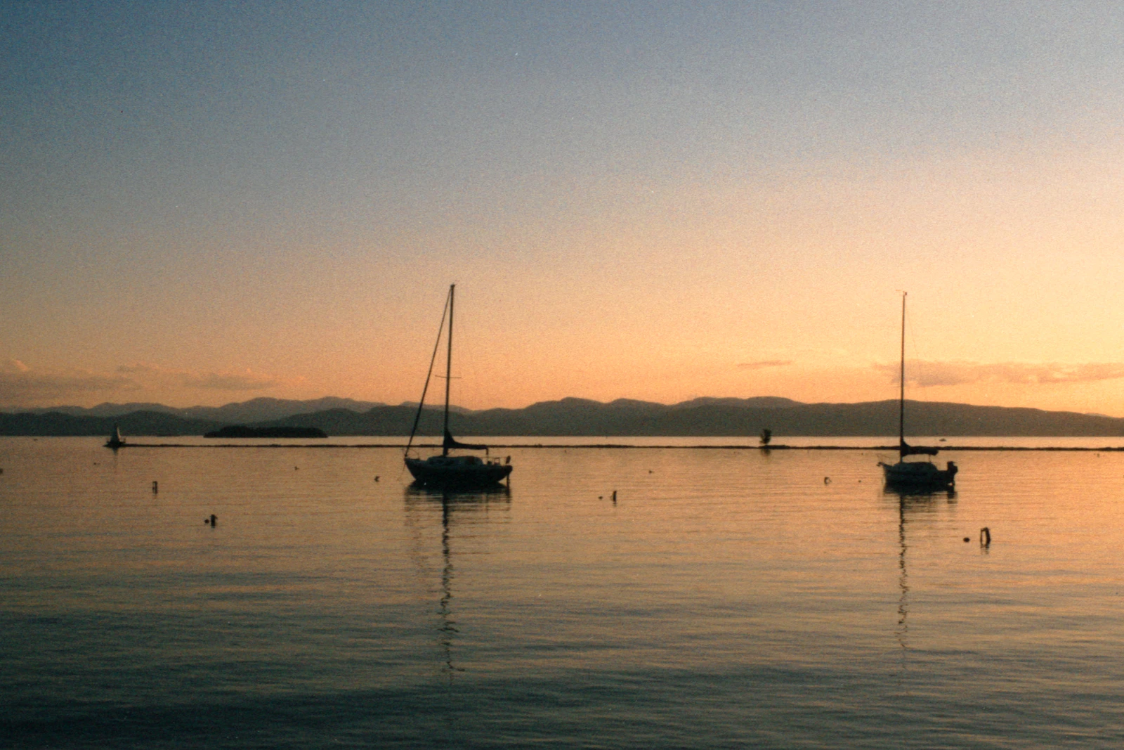 Boats on Lake Champlain at sunset with mountains beyond, Burlington, Vermont