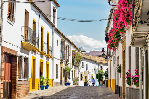 A cobblestone street lined with white and yellow buildings