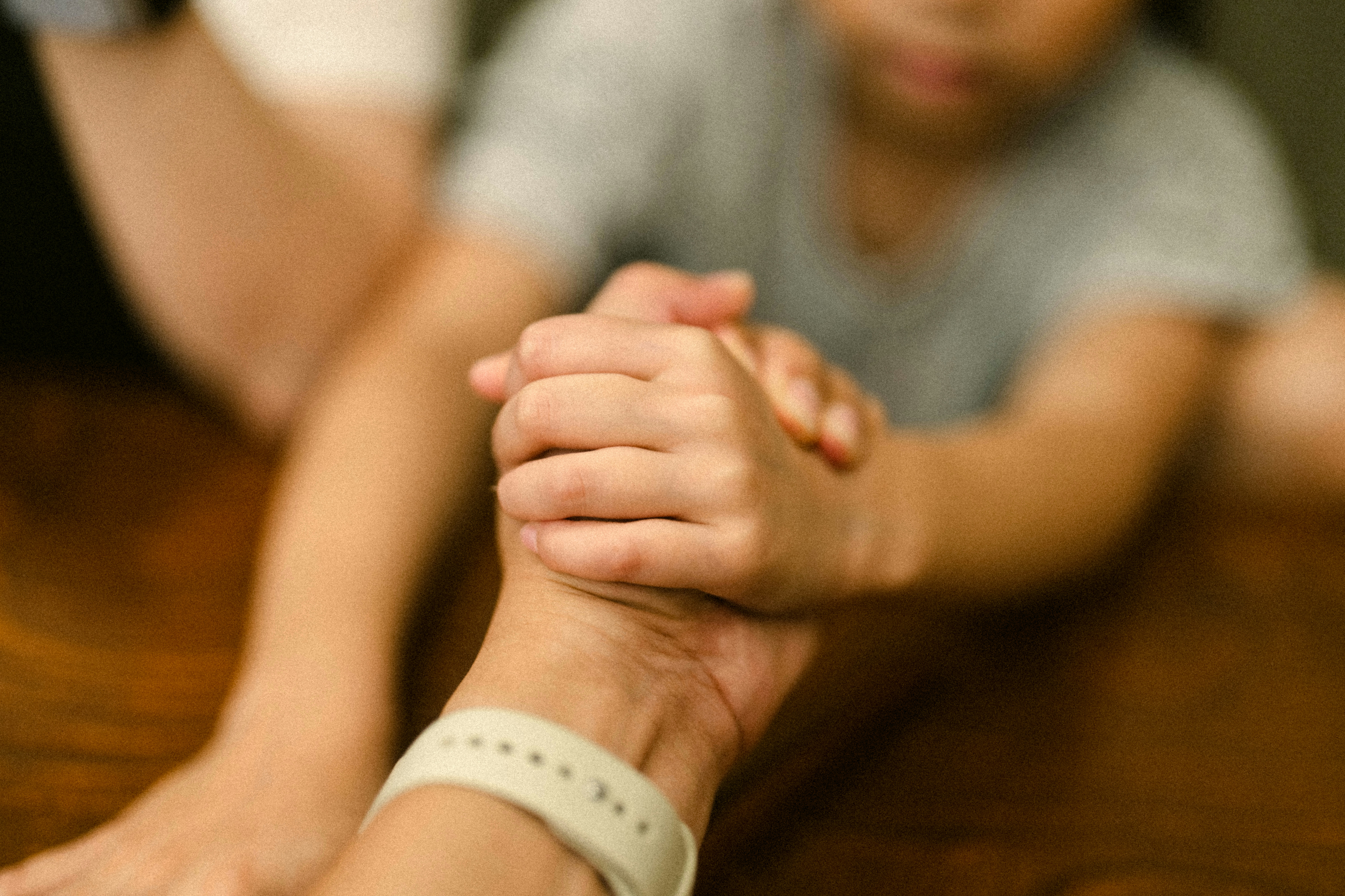 A person sitting at a table with a cell phone in their hand