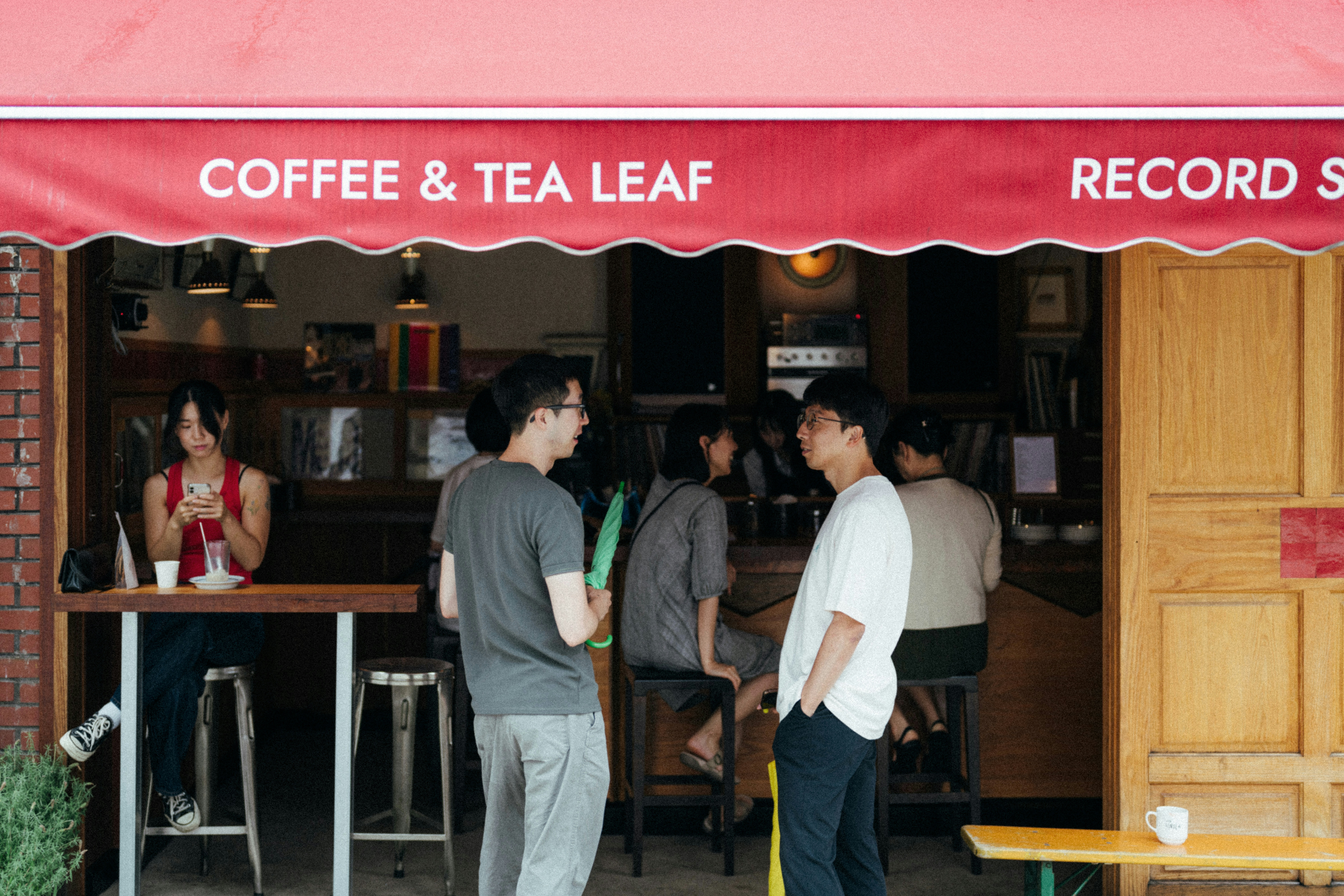A group of people standing outside of a coffee shop