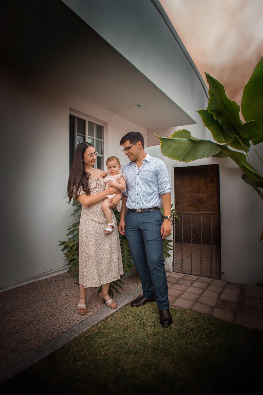 First-time buyers with their baby in front of their new home