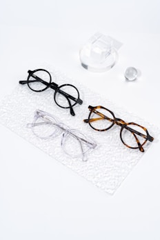 Three pairs of glasses sitting on top of a white surface