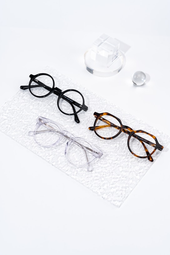 Three pairs of glasses sitting on top of a white surface