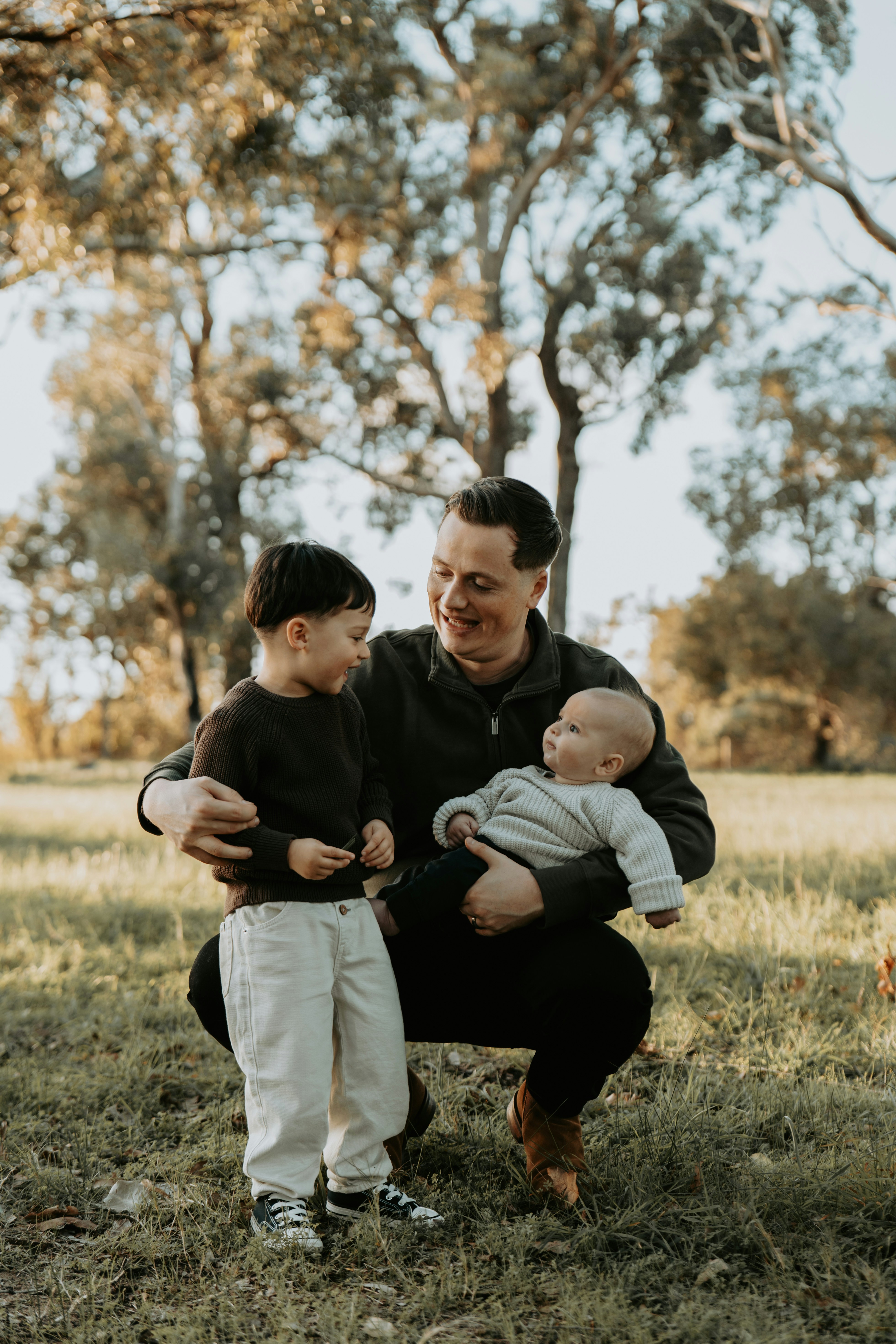 A man holding a baby in a field