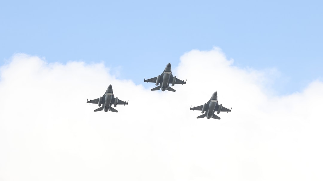 A group of fighter jets flying through a cloudy sky, Three F-16 fighter jets in formation flight.