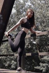 A woman in a black sports bra top and leggings