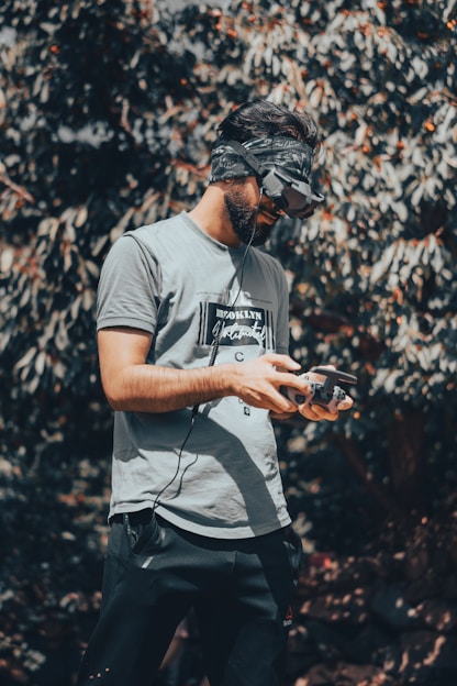 A man standing in front of a tree using a cell phone