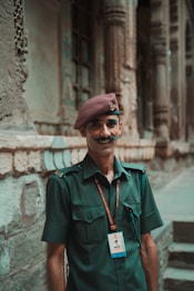 A man with a mustache standing in front of a building